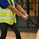 Professional Asian male warehouse worker pulling the pallet truck with parcel boxes, working in warehouse. cropped shot